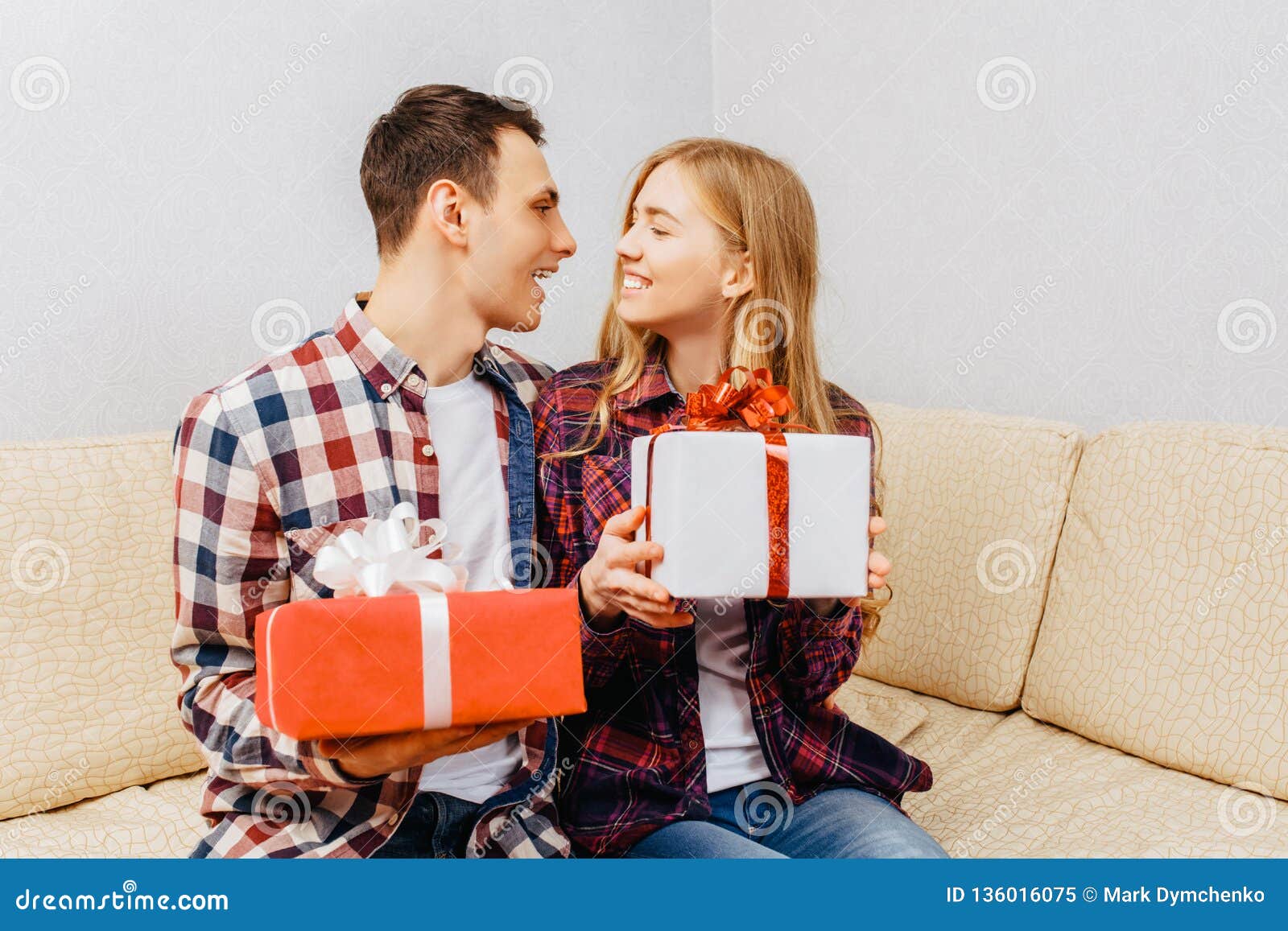 young couple man woman give each other gifts sitting home couch valentines day concept young couple men 136016075